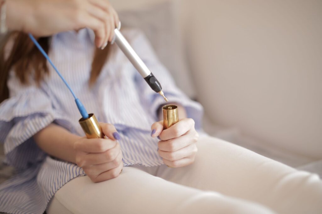 A bioresonance device connected to a patient’s hand, analyzing energy frequencies to assess health and detect imbalances.