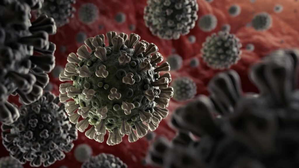 A medical professional in protective gear administering a COVID-19 vaccine, with a virus graphic in the background.