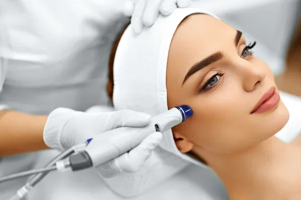 "HydraFacial machine with handpiece and control panel in a clinical setting"