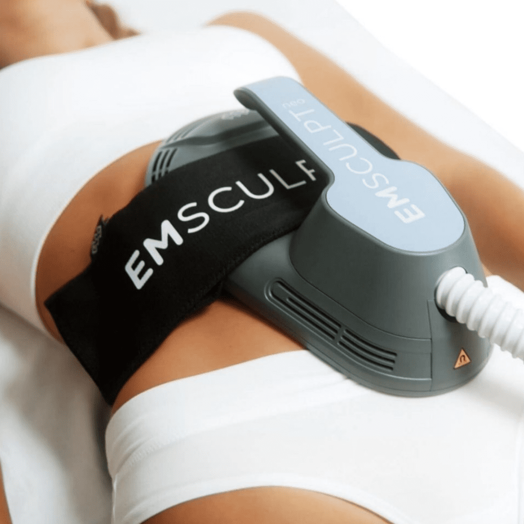 "A person undergoing an Emsculpt treatment session, with the device applied to their abdomen to tone muscles and reduce fat."