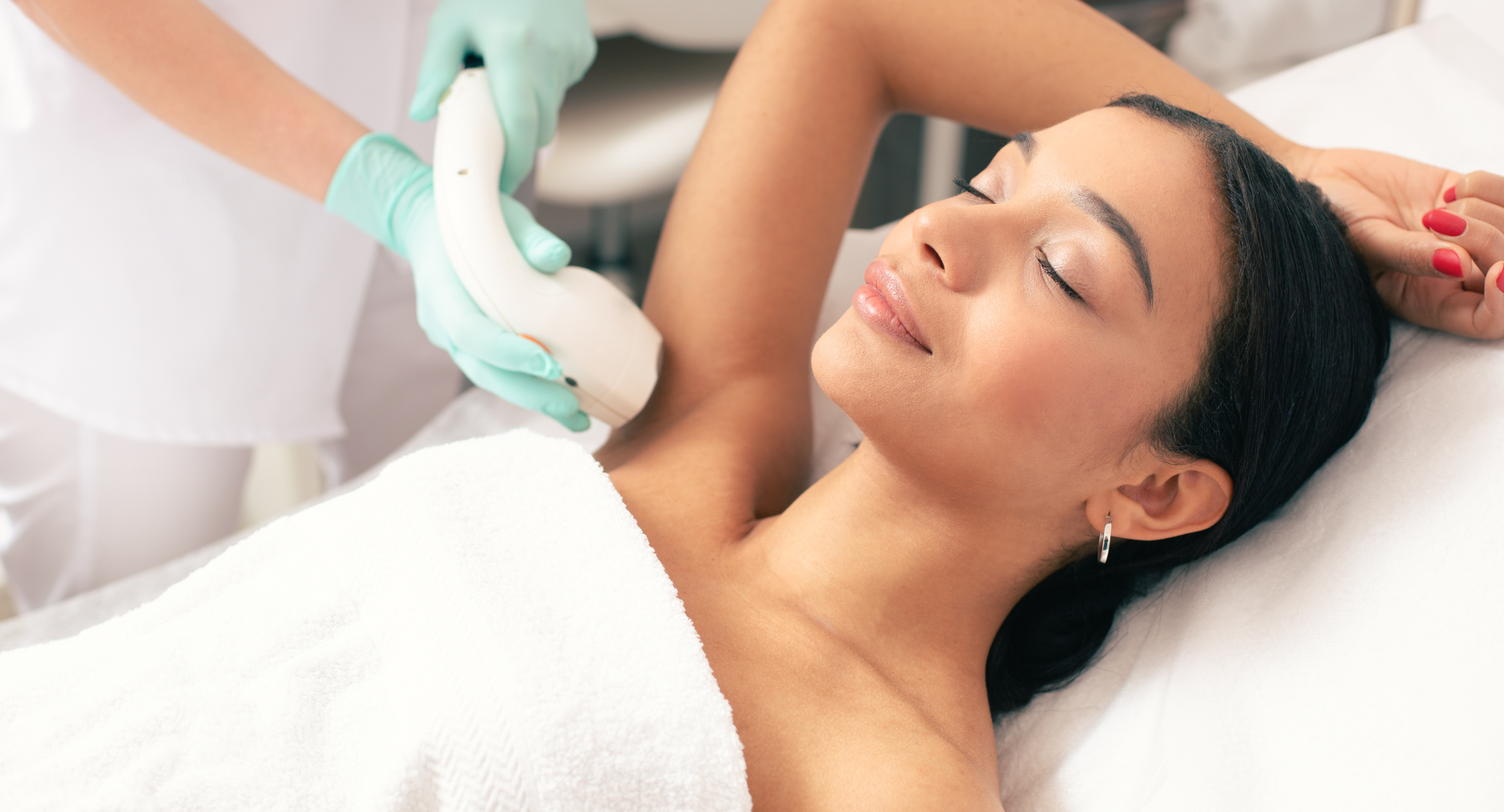 A professional conducting a laser hair removal treatment on a client’s leg in a modern clinic setting.