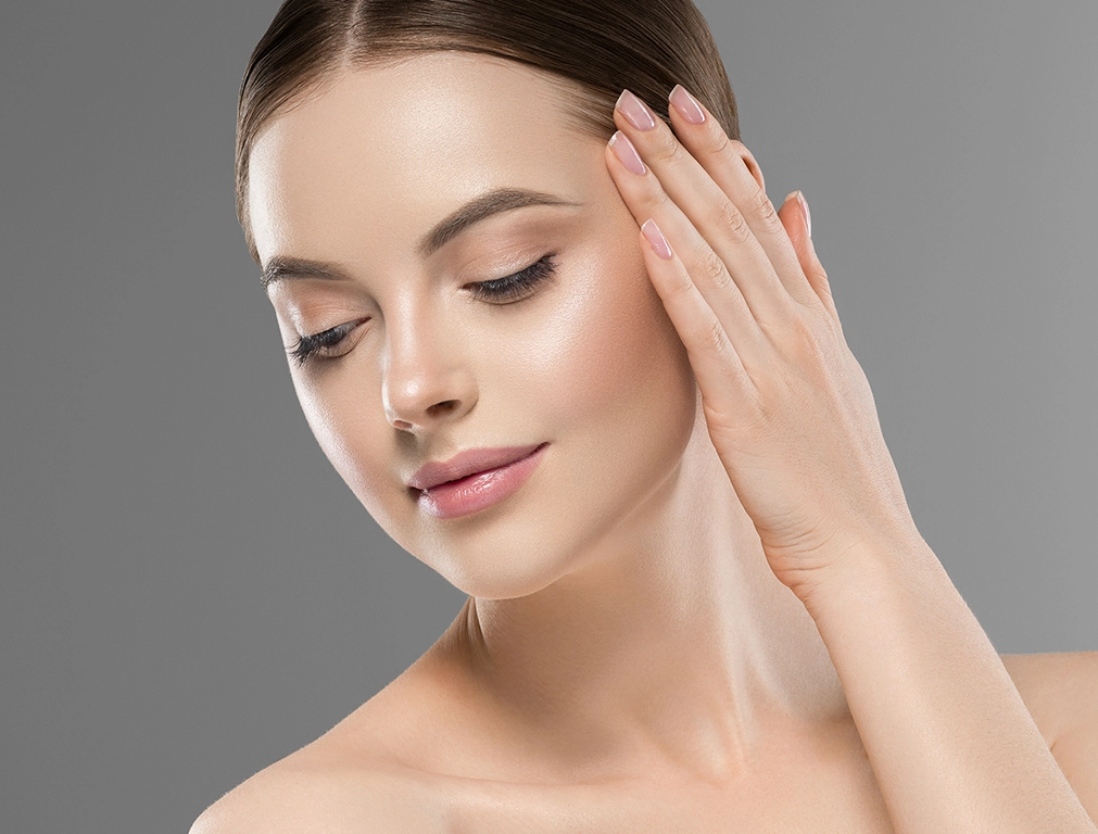 "Close-up of a woman's face with radiant, glowing skin, showcasing a healthy skincare routine."